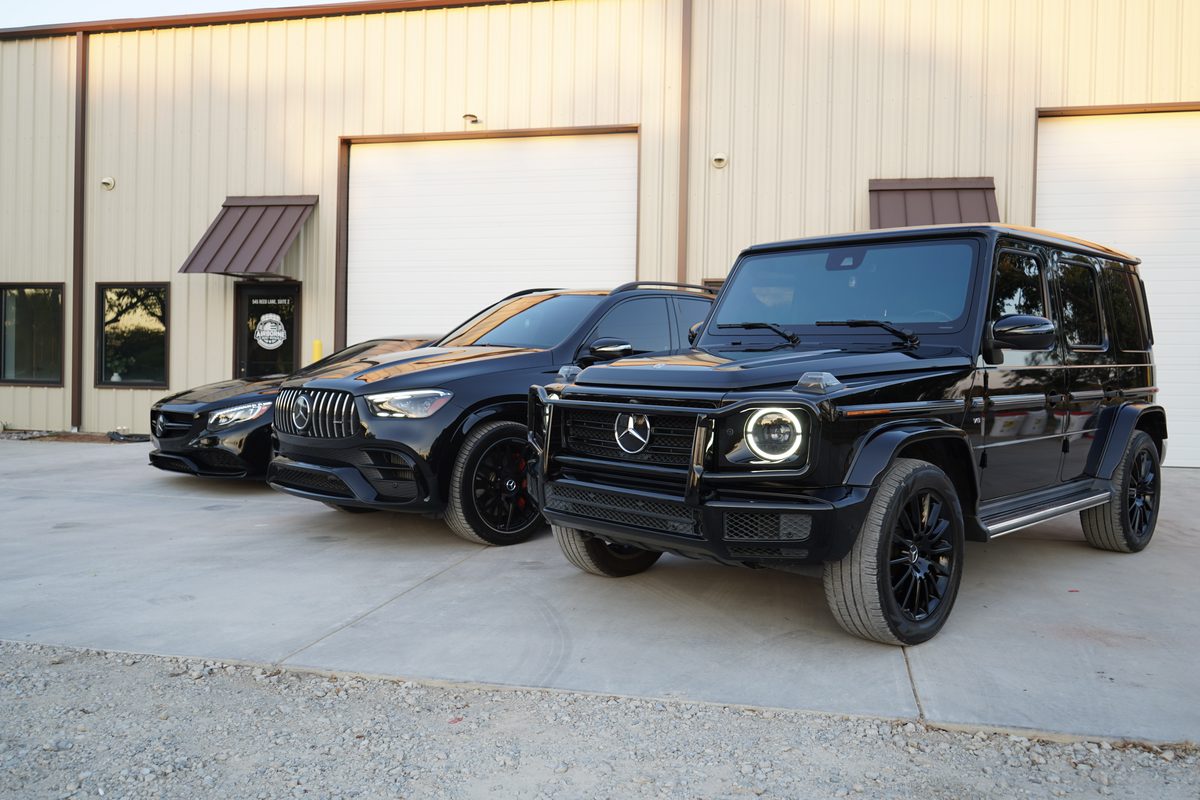 A Mercedes-AMG G 63 at the head of a line of vehicles outside the shop